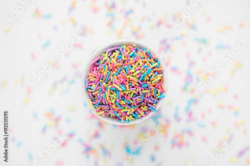 Colorful Pastel Sprinkles in a cup on white backdrop with copy space