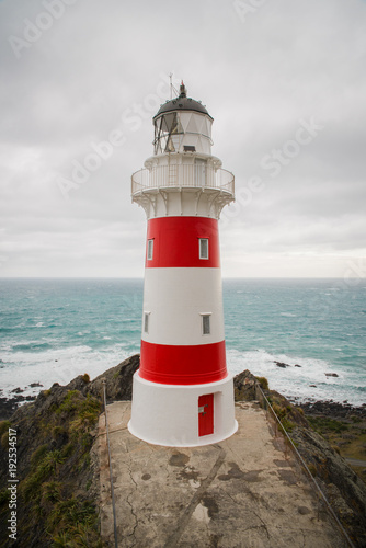 Close up of a light house with the oceand in the background at Cape Palliser, New Zealand. 