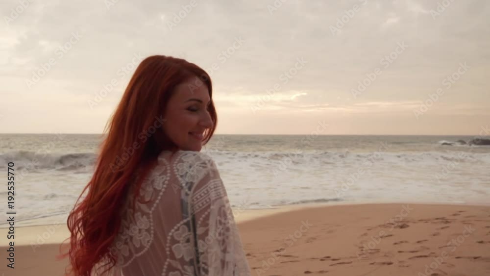 happy young red-haired woman enjoys relaxing on the ocean, slow motion, evening happy young red-haired woman enjoys relaxing on the ocean, slow motion, evening