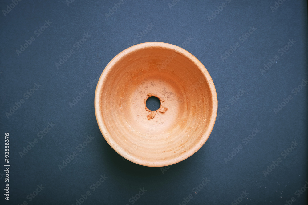 Empty orange clay flowerpot top view with black background. Empty orange clay flowerpot top view with black background.