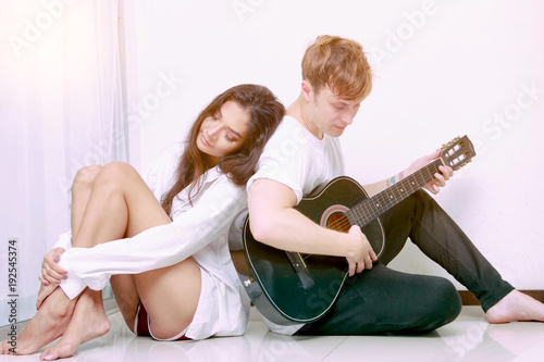 Couple in love playing acoustic guitar in the home