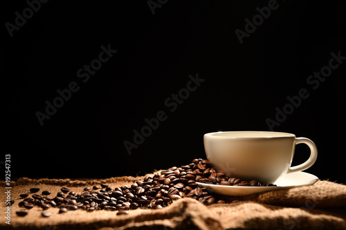 Coffee cup and coffee beans on black background