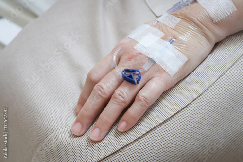 Patient s hand with drip receiving a saline solution.