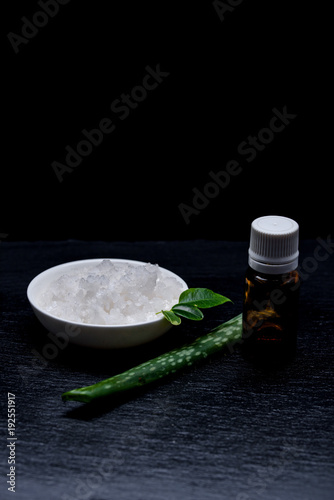 Marine cosmetic salt in a white pial with leaves and aloe on a slate board photo