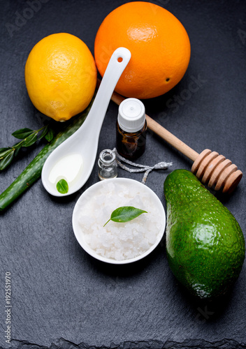 Sea cosmetic salt in a white pial with aloe orange lemon and avakado on a slate board photo