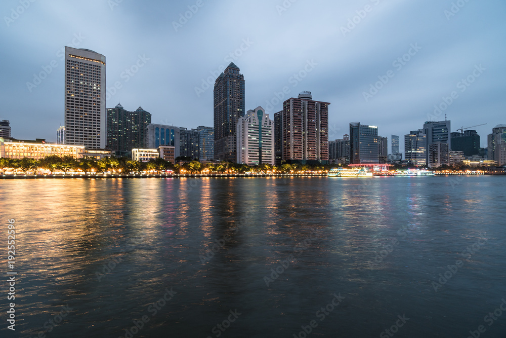 Office buildings and hotel tower reflect in the water of the Pearl river that crosses the Guangzhou downtown district
