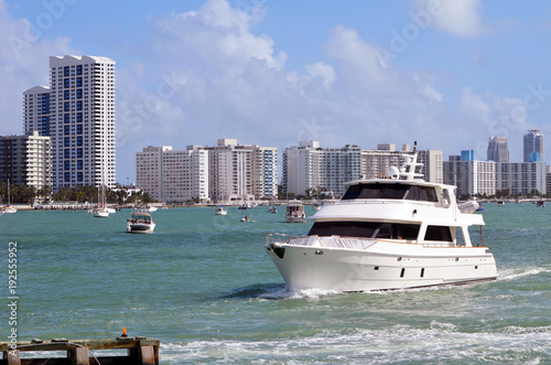 Retro white yacht on the florida intra-coastal waterway with south Miami Beach condo skyline in the background. © Wimbledon
