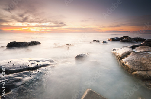 long expose sunset seascape with waves trails. image contain soft focus due to long expose.