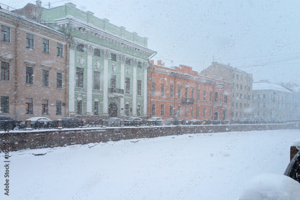 Typical for St. Petersburg, snowy and windy weather in the winter afternoon. Embankment of the snow-covered Moika River