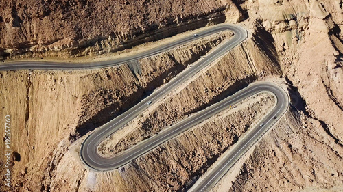 Canvas-taulu Desert road - Aerial image of traffic going up and down a serpentine mountain ro