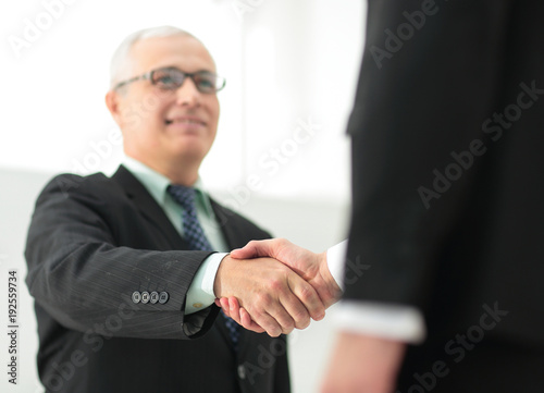 closeup of a business handshake partners. the image is blurred.