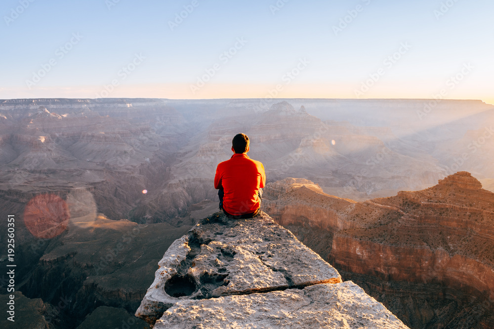 Fototapeta premium young boy at the edge of the cliff in colorado grand canyon, Usa