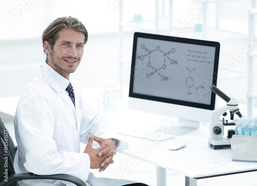 Portrait of a male scientist with a monitor looking at the camer