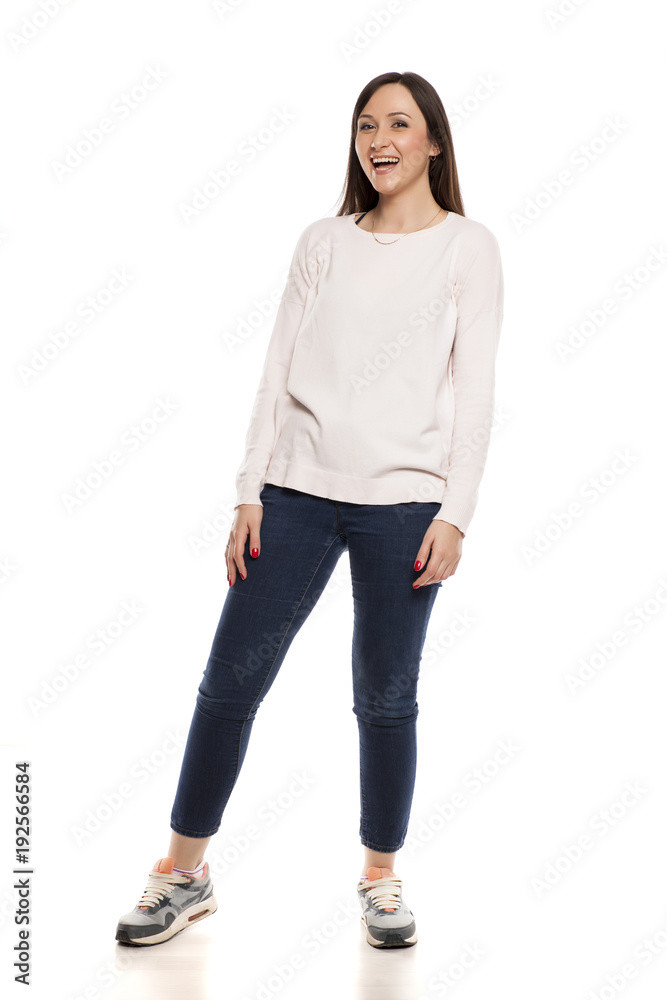 Young happy woman in jeans, blouse and snekaers on white backgeound Young happy woman in jeans, blouse and snekaers on white backgeound