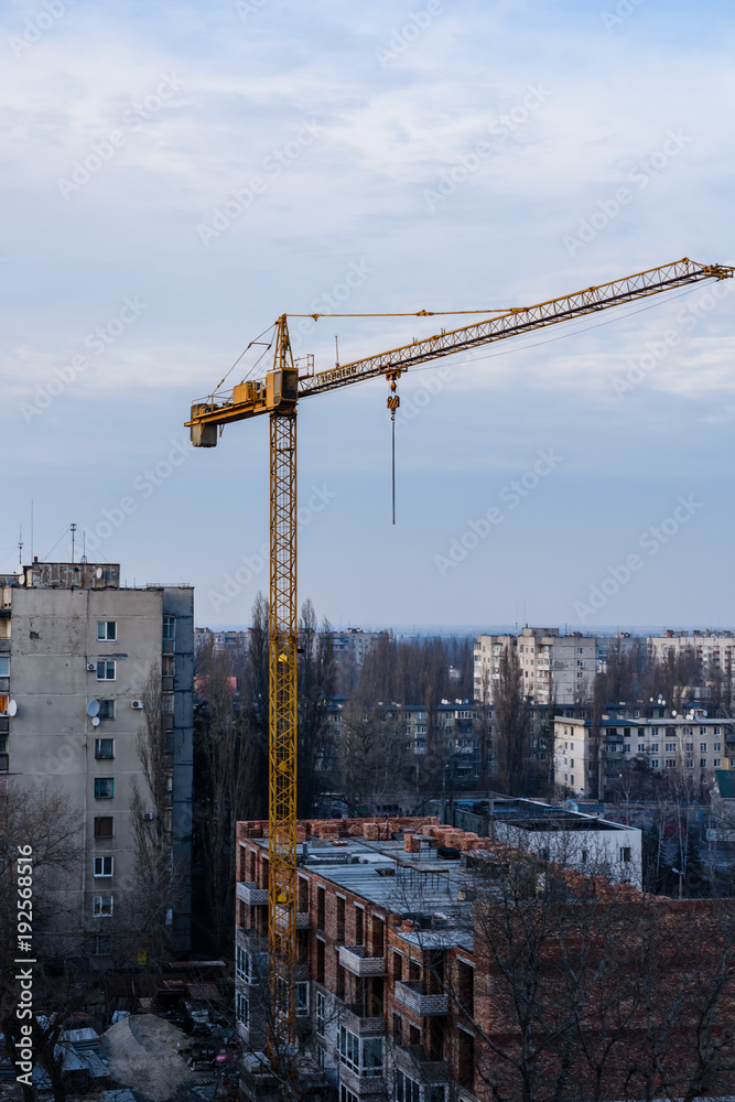 Tall construction crane at a building site