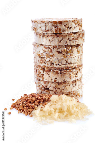 Diet rice cakes pile with buckwheat and rice grains isolated on white background photo