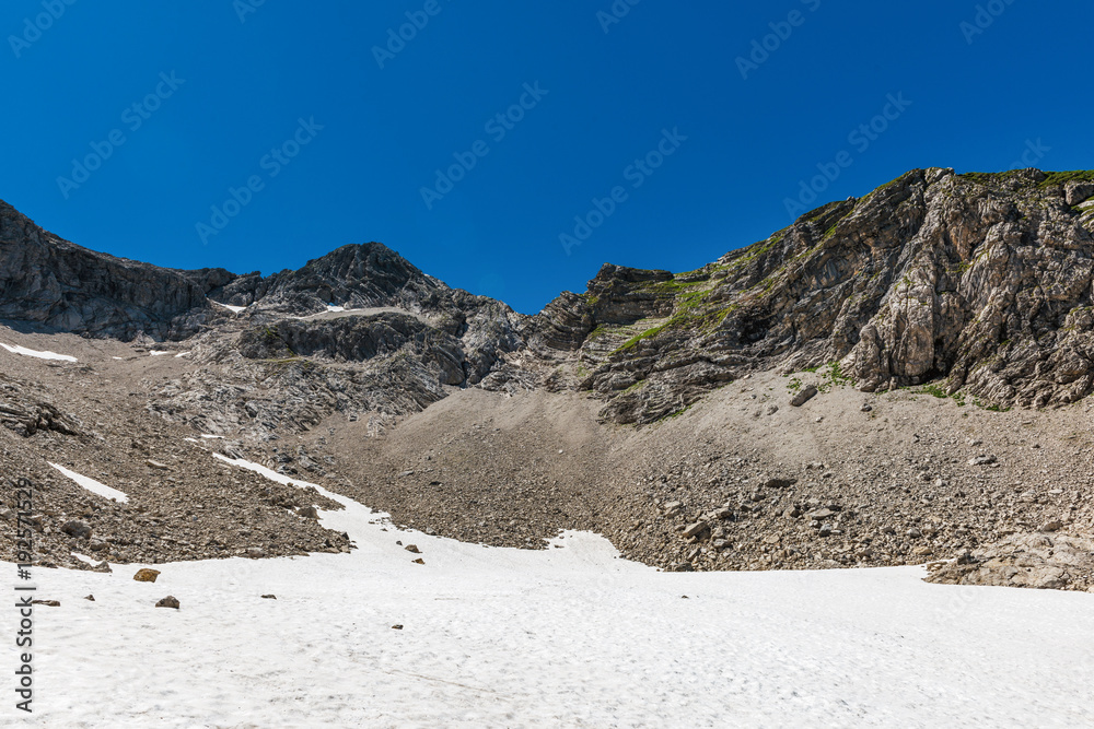 Snow field and rock faces in an alpine surrounding
