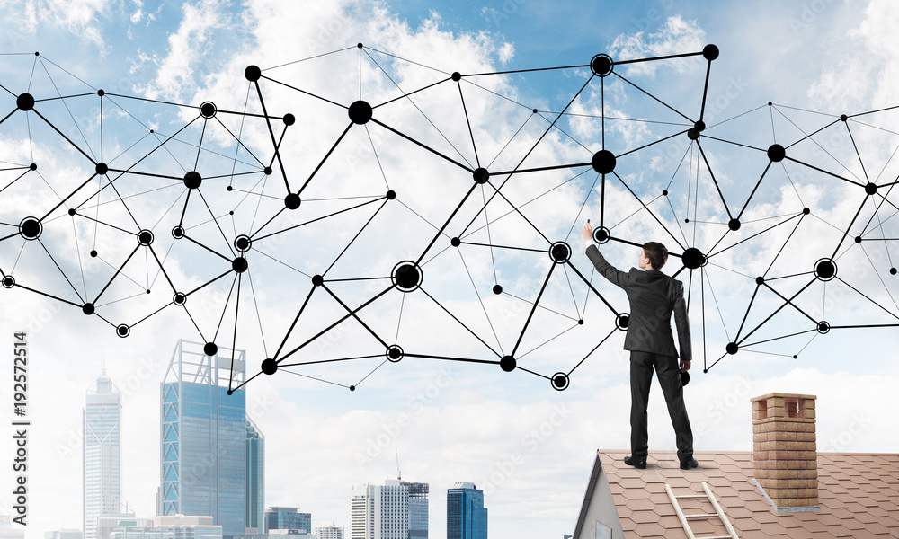 Businessman on house roof presenting networking and connection concept. Mixed media Businessman on house roof presenting networking and connection concept. Mixed media
