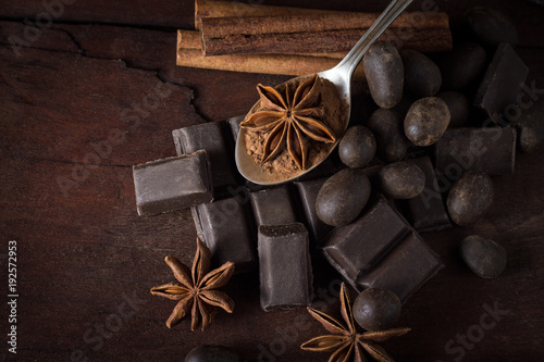Black Chocolate, Spices, Tea Spoon on Wooden Background