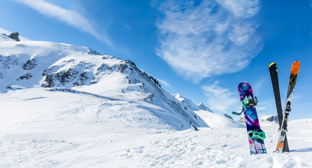 Photo of crossed skis and sticks against background of snowy landscape