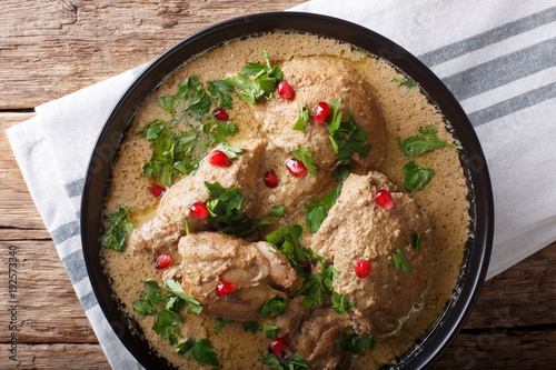 Delicious Georgian satsivi with chicken and pomegranate close-up in a bowl. Horizontal top view photo