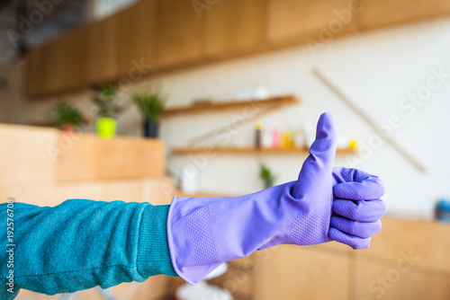close-up partial view of woman in rubber glove showing thumb up
