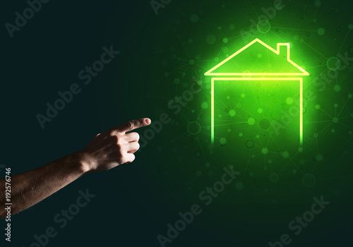 Conceptual image with hand pointing at house or main page icon on dark background