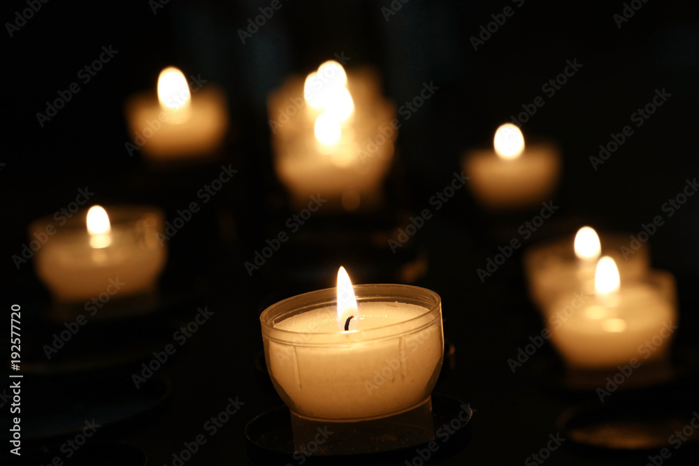 White candles burning in dark church close up White candles burning in dark church close up
