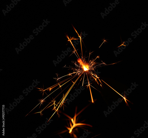 Close up one firework sparkler over blue bokeh