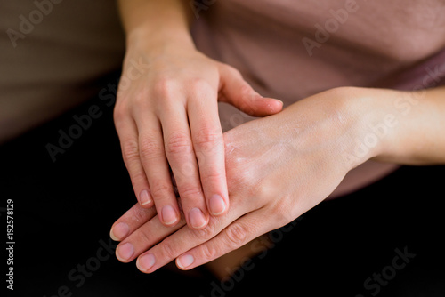 Young woman hands, She applying a cream on her hands, for saving her skin