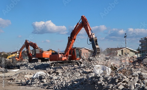 Excavators at work in the ruins of a demolished building for urban redevelopment