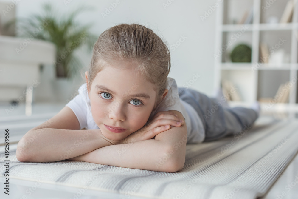 close-up portrait of little child lying on yoga mat and looking at camera close-up portrait of little child lying on yoga mat and looking at camera