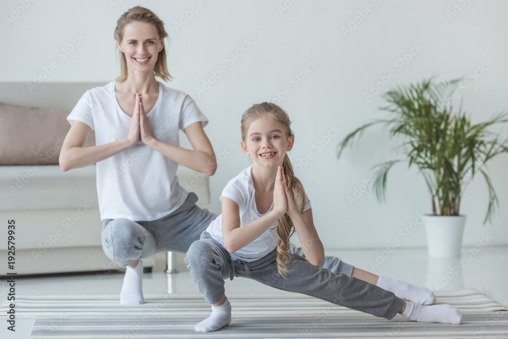 mother and daughter practicing yoga together at home