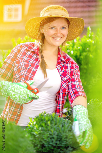 Fröhliche Frau im Garten beim Pflanzenpflege photo