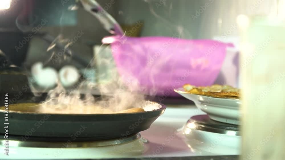 fried pancake in a frying pan on the background of ready-made pancakes lying on a plate fried pancake in a frying pan on the background of ready-made pancakes lying on a plate