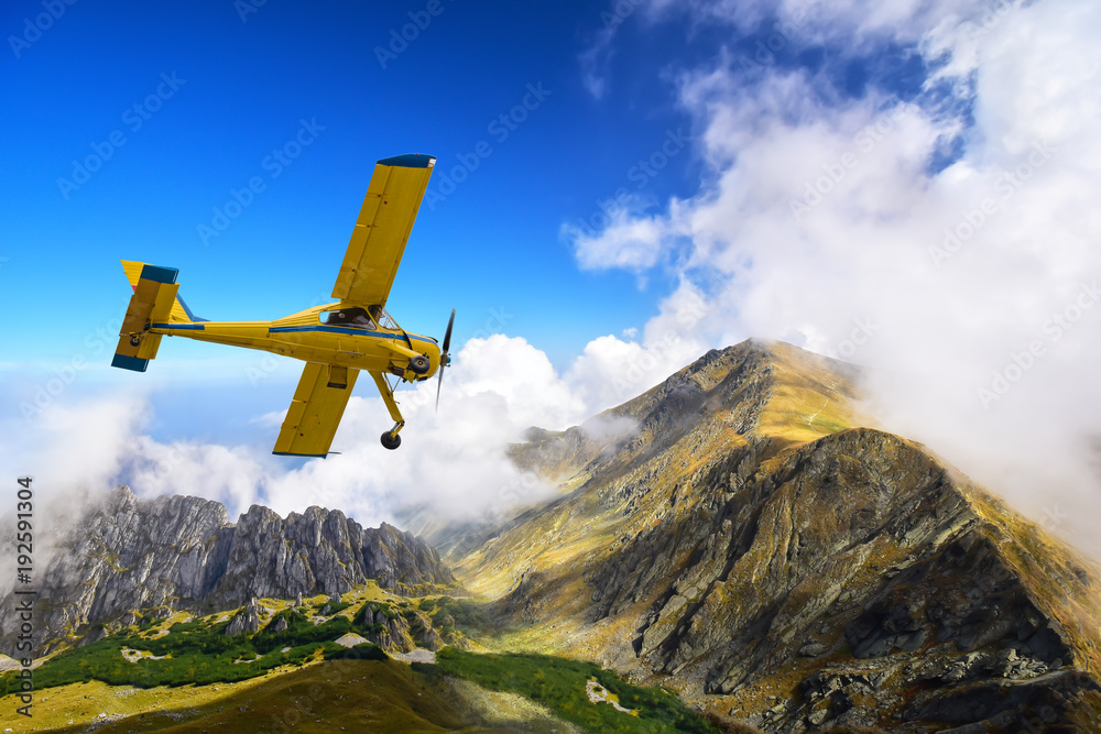 Fototapeta premium Stary i zabytkowy samolot cessna latające nad karpackimi szczytami górskimi w Rumunii
