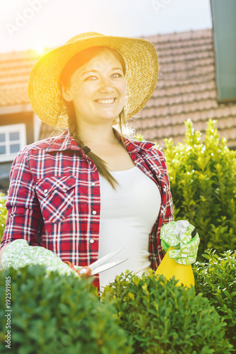 Fröhliche Frau im Garten beim Pflanzenpflege photo