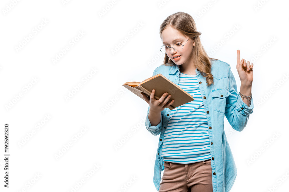 beautiful teenage girl in eyeglasses reading book and pointing up with finger isolated on white beautiful teenage girl in eyeglasses reading book and pointing up with finger isolated on white