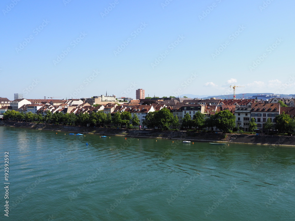 Bank on Rhine River in swiss city center of Basel in Switzerland with representative historical buildings