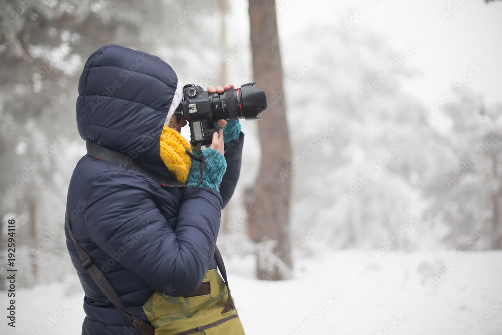 woman with camera in snowy mountains