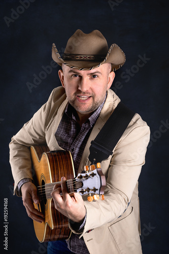 The man's portrait in a cowboy's hat on dark background