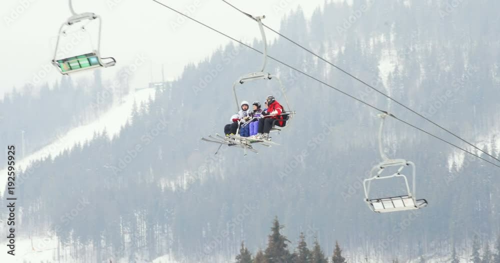 skiers sitting chair ski lift moving up winter ski resort amazing wild nature forest snowy trees background skiing people active hobby sport lifestyle vacation freshness tourism mountains downhill skiers sitting chair ski lift moving up winter ski resort amazing wild nature forest snowy trees background skiing people active hobby sport lifestyle vacation freshness tourism mountains downhill