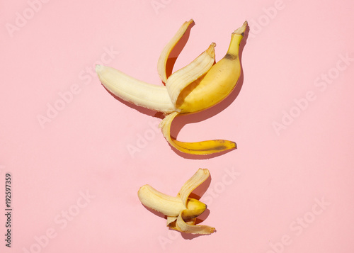 Sweet juicy opened little banana and opened big banana on pink table. Sexual life libido, penis size and potency concept.