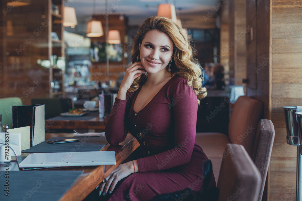Smiling Woman in Restaurant. Beautiful Model Sitting in Cafe