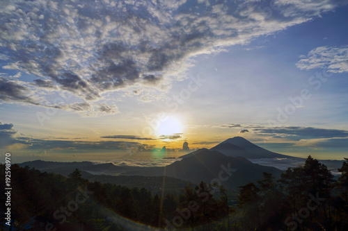Dawn overlooking the 3 mountains at the same time, Agun, Batur at Bali island. A small smoke from the volcano. Side view with copy space
