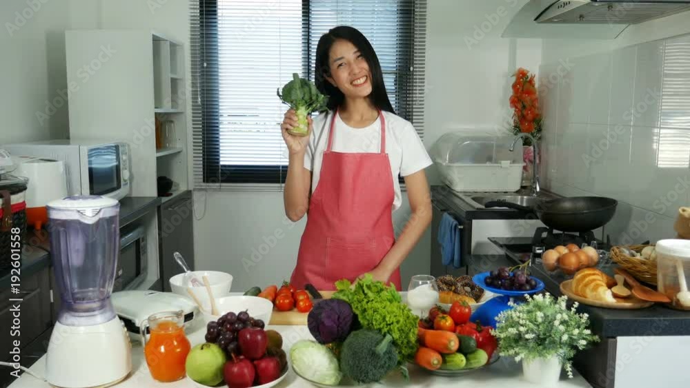 4k of woman holding broccoli and carrot and cucumber and tomato in kitchen room at home 4k of woman holding broccoli and carrot and cucumber and tomato in kitchen room at home