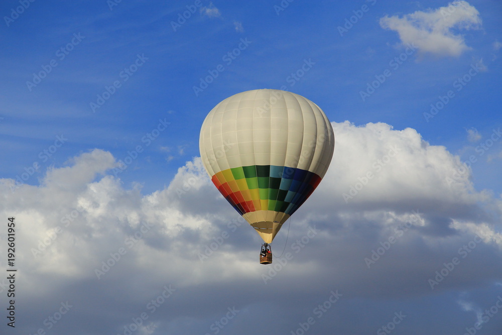 Naklejka premium Many colored aerostatic balloon flying in a blue sky with white clouds