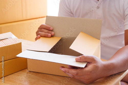 Young man packing parcels.