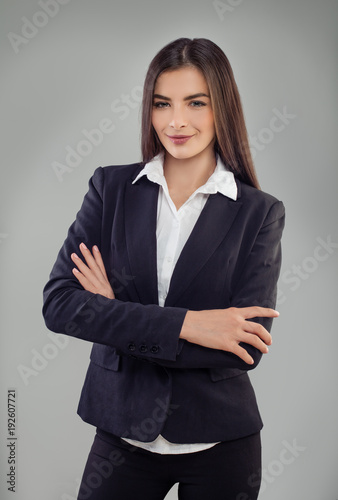 Casual business woman with arms crossed and smiling on gray background