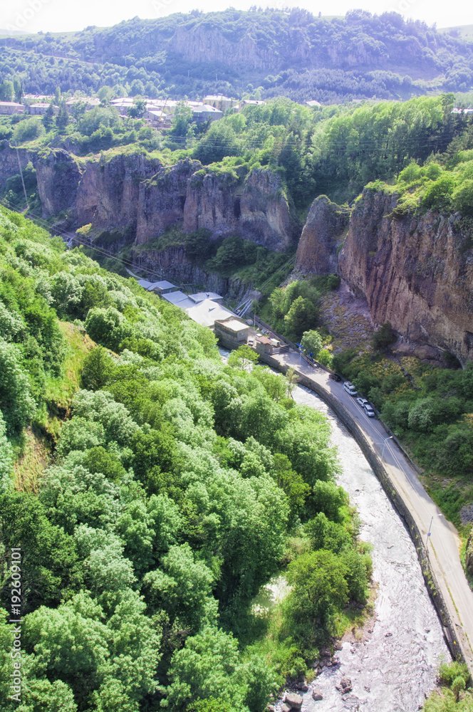 Gorge of the Arpa River. View of the mountains, the river, the road and the blue sky. The city of Jermuk, Armenia.